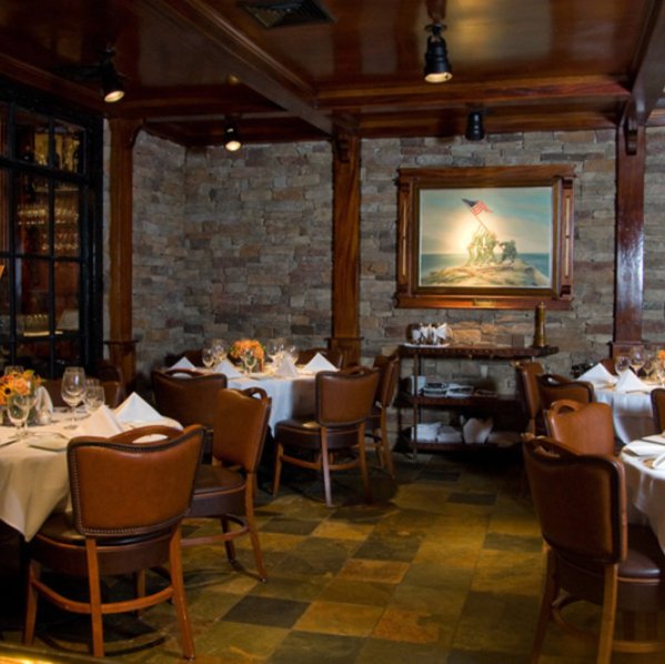 Roots Steakhouse interior dining room with white-linen tables and stone accents